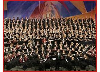 large choir and orchestra in formal attire on stage