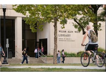 william allen white library with students and a cyclist