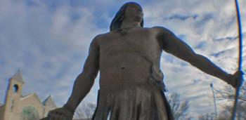 statue of a Native American figure with a spear