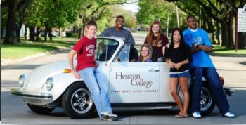 students around a car with 'Hesston College' logo