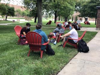 students sitting outside on red chairs