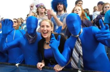 fans in blue bodysuits cheering at a sports event