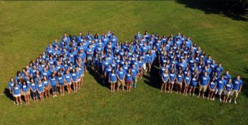 group of people arranged to form a '23' on a grass field