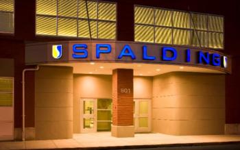 illuminated 'spalding' sign on building at twilight