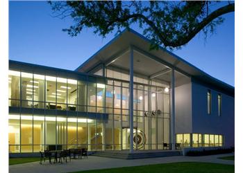 illuminated modern building facade at dusk with trees