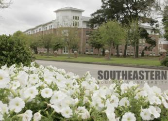 white flowers in foreground with 'southeastern louisiana university' sign