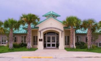 front view of a building with palm trees