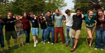 group of students posing with linked arms in a park