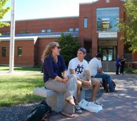 two people sitting and talking outside a campus center