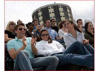 group of students sitting outdoors, laughing