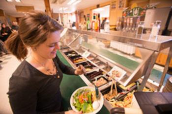 student serving herself food in a buffet line