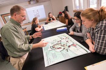 professor and students discussing around a poster