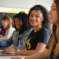 students smiling in classroom with 'bowie state university' shirts