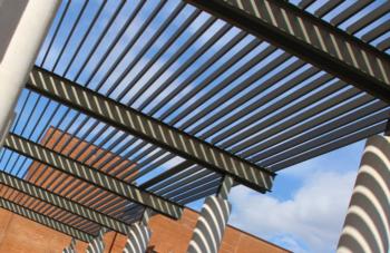 architectural detail of a pergola against a clear sky