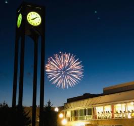 clock tower at night with fireworks in the background