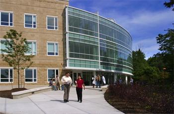 two people walking outside modern glass building