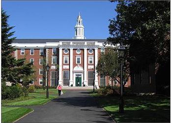 brick building with white columns, bell tower, and pedestrian