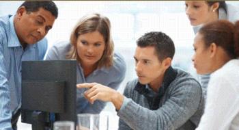 group of people in a meeting looking at a computer screen