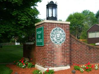 brick sign with 'Mount Ida College' and lamp on top