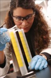 scientist examining a test tube with yellow substance