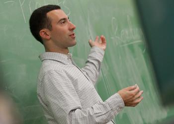 professor teaching at chalkboard