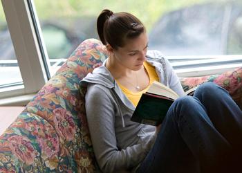 student reading on a sofa