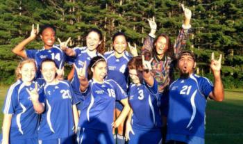 soccer team posing with victory signs