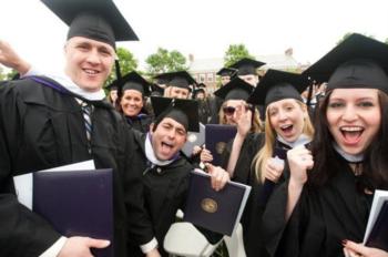 group of graduates smiling and holding diplomas