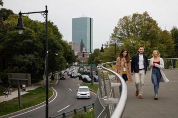 three people walking near a city overpass