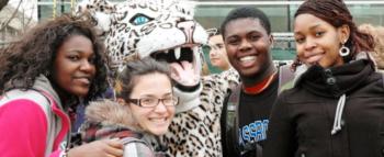 four students posing with a person in leopard mascot costume