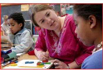 teacher helping student in classroom