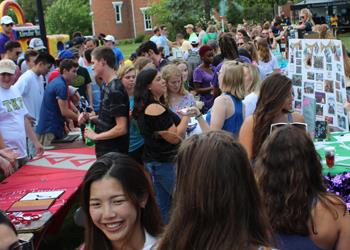 students at an outdoor college event with booths