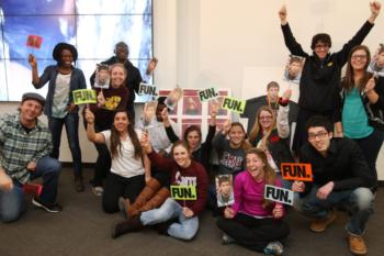 group of people holding signs with 'FUN.'