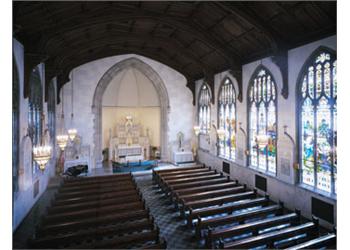 interior of a chapel with pews and stained glass windows