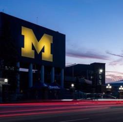 illuminated 'M' logo at twilight with light trails