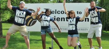 four students jumping in front of 'welcome to wmu' sign