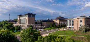 campus buildings with lush greenery under blue sky