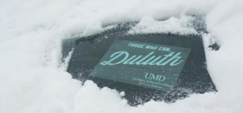 sign 'Duluth UMD' partially covered with snow