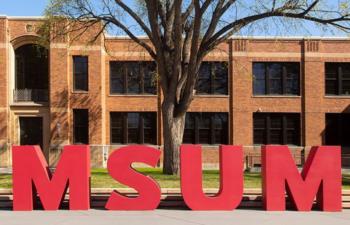 large 'MSUM' letters in front of a brick building