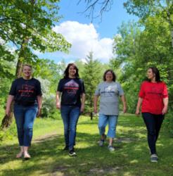 four people walking outdoors on a sunny day