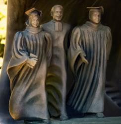 statues of three figures in academic regalia