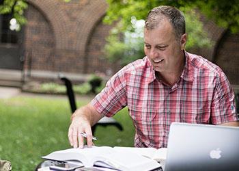 man studying outdoors with laptop