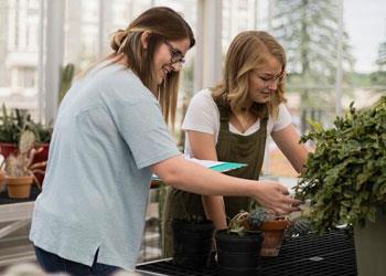 two students working in a greenhouse