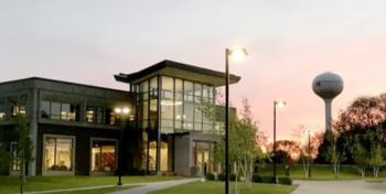 campus building at dusk with water tower in background