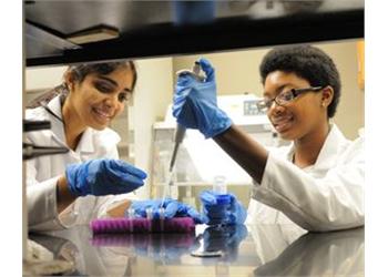 students in lab coats conducting an experiment