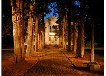 historic building at night with illuminated pathway