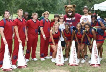 group of students with mascot and 'fear the bear' sign