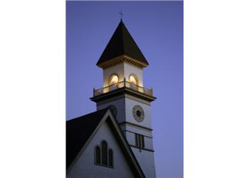 church tower lit up at twilight