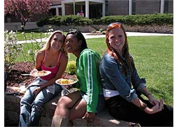 students sitting outdoors with plates of food