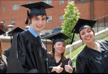 three people in graduation attire smiling